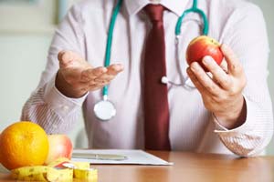 Doctor inviting to eat fresh fruit