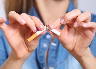 Hands breaking a cigarette, an invitation not to smoke