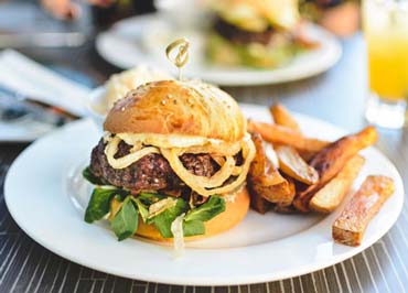 Dish with hamburger and fries, symbol of high-calorie food